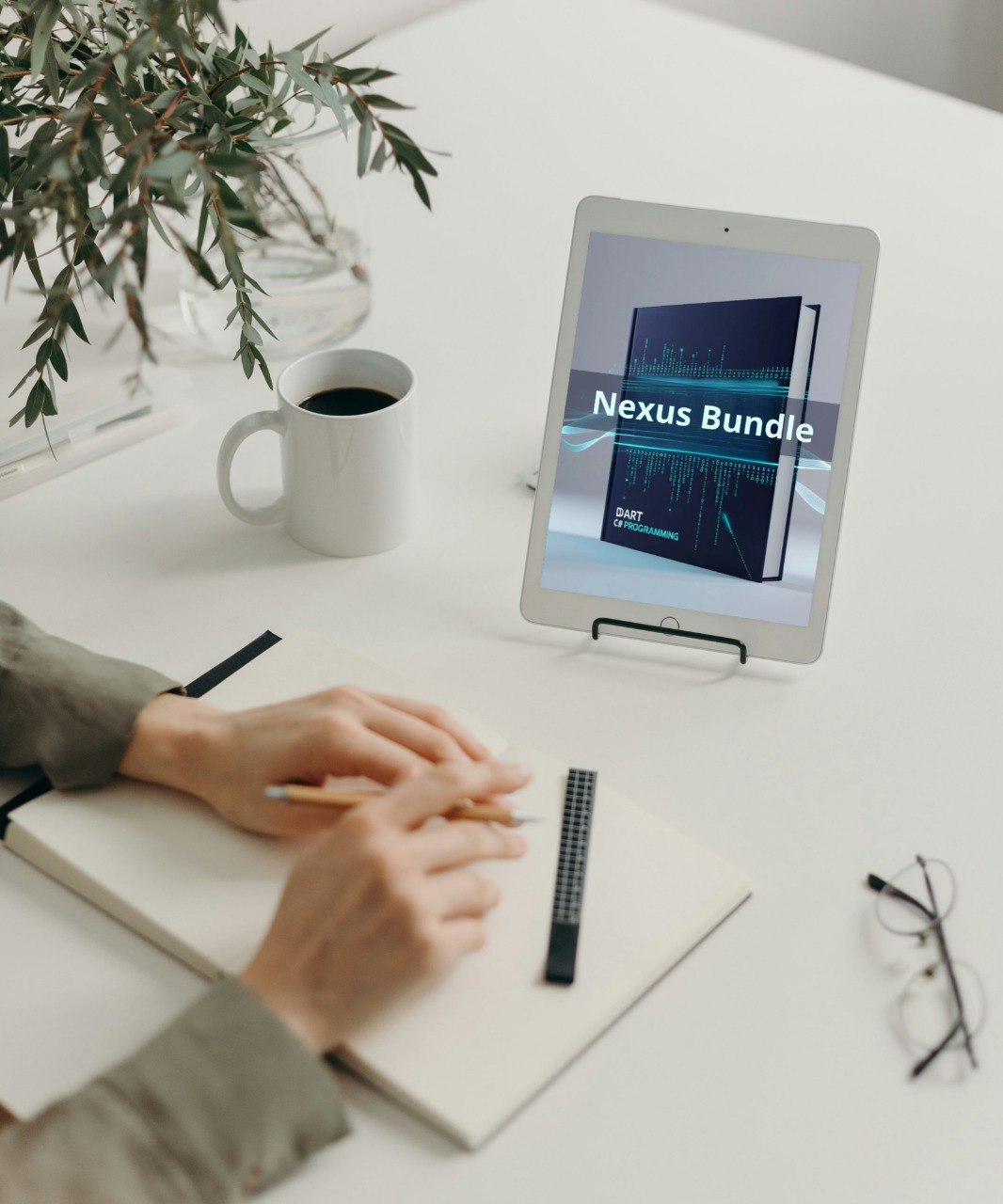 Person working on a tablet displaying 'Nexus Bundle' on a desk with a cup of coffee and plant.