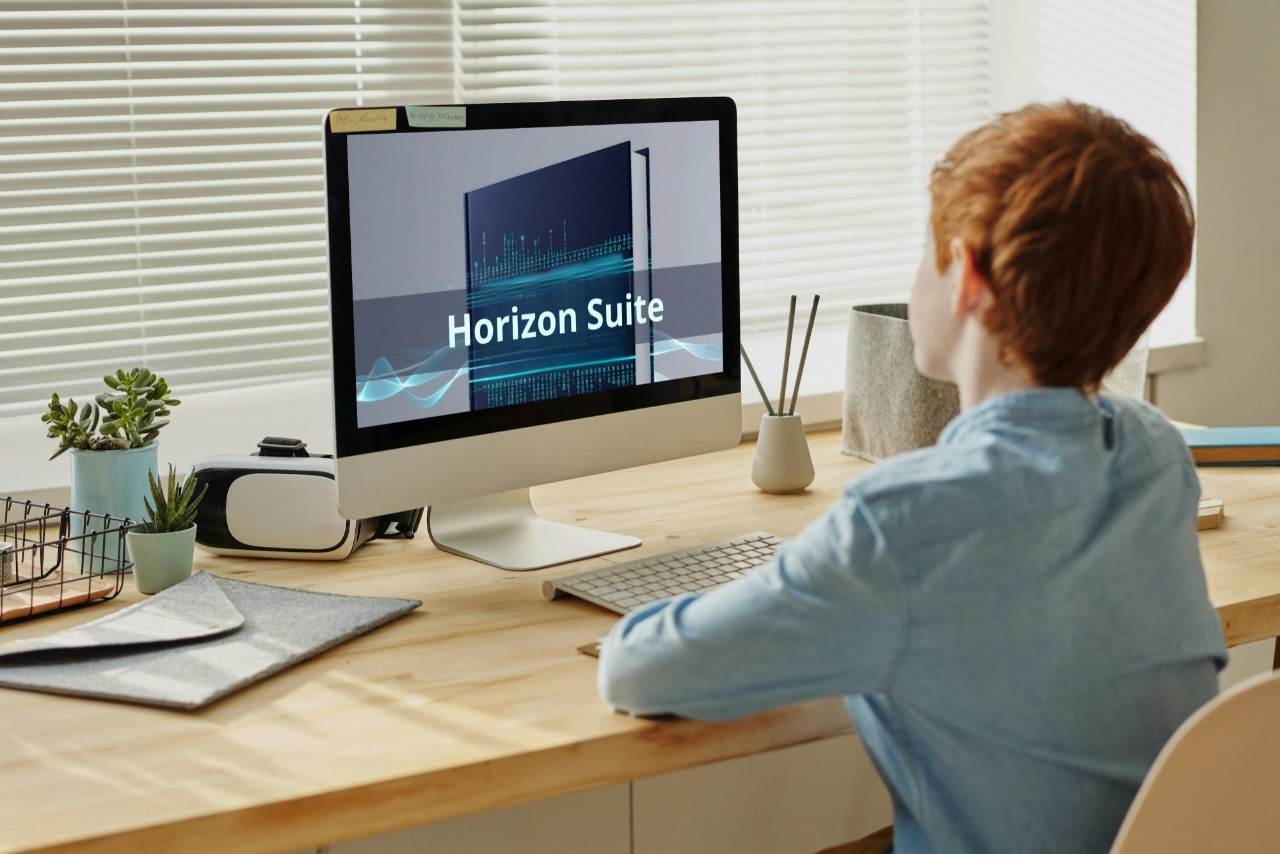 Person using a computer with 'Horizon Suite' on the screen at a desk.